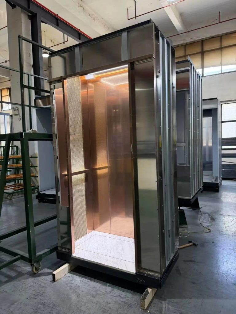 Bronze-panelled Nexco elevator cabin with marble floor