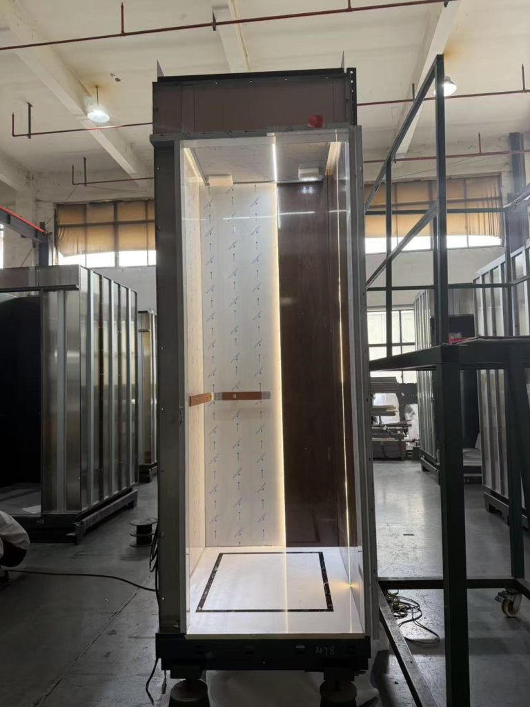 Nexco elevator cabin with marble panels and handrail